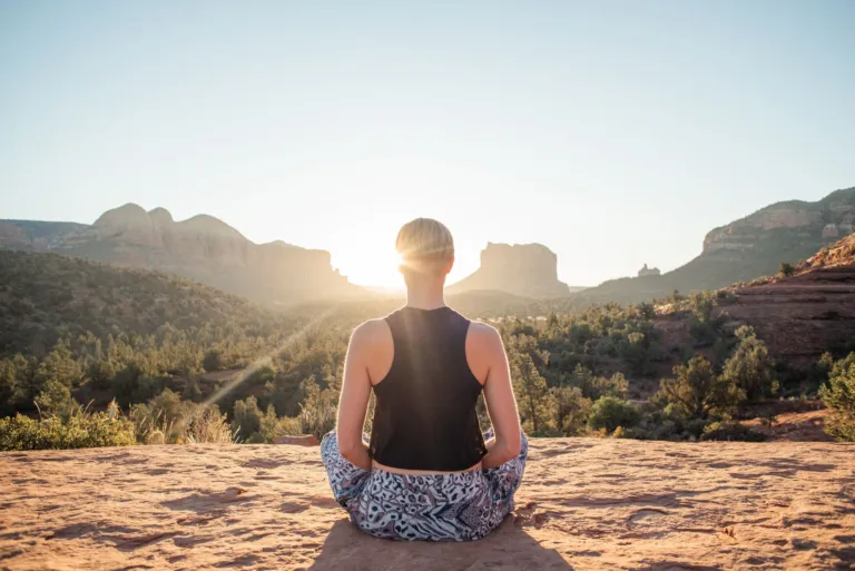 Woman meditating at sunrise to support calm and mental health