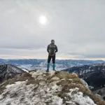 Hiker standing on a mountain summit after a challenging climb