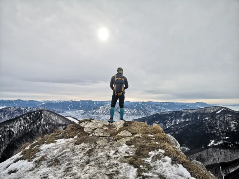 Hiker standing on a mountain summit after a challenging climb