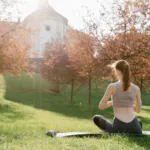 Person sitting calmly outdoors practicing slow breathing in nature