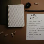 Open planner notebook with a pen on a desk for writing goals
