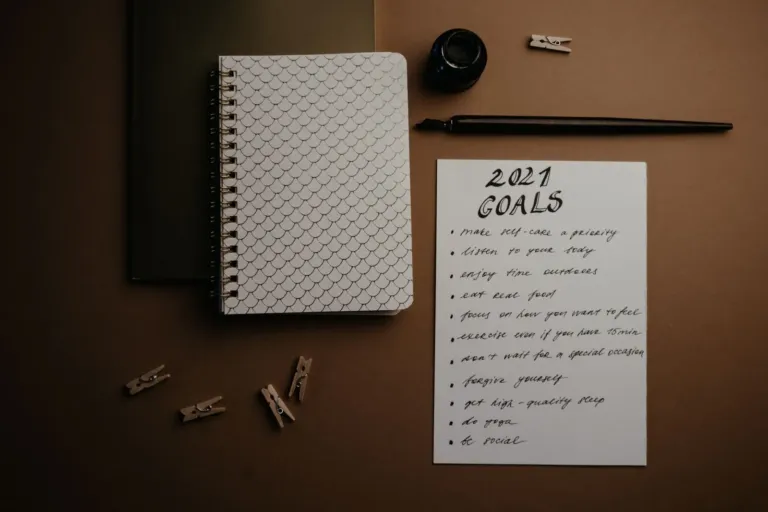 Open planner notebook with a pen on a desk for writing goals